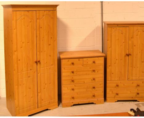 A modern pine bedroom suite comprising twin-door wardrobe, width 79cm, a smaller tallboy, width 79cm and a two-over-four ches