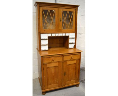 A 20th century pine dresser, two astragal glazed doors above named ceramic drawers, pull-out work surface, two short drawers 