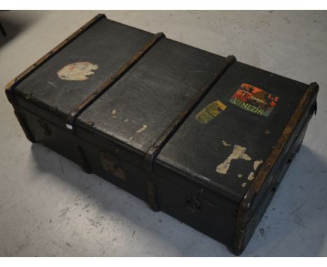 A vintage Au Départ green canvas covered trunk with integral lift-out tray, bearing remnants of various luggage labels and Au