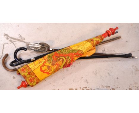 Three vintage walking sticks, a shooting stick and a decorative wall hanging on red pole (5).
