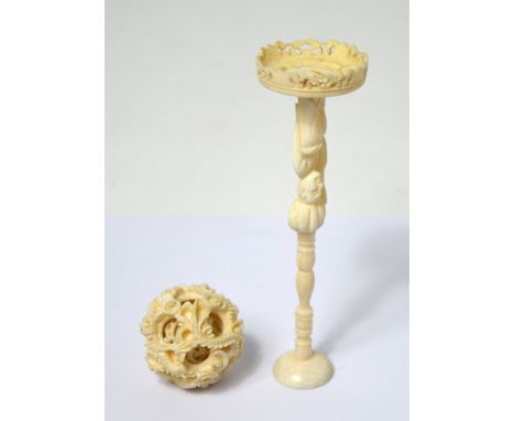 An early 20th century heavily carved ivory five globe puzzle ball raised on a figural pedestal stepped base, height 15.5cm. C