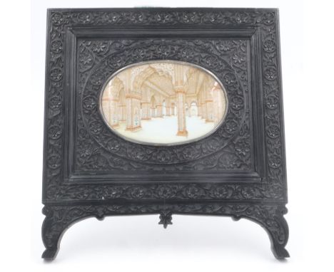 A large Middle-Eastern painted miniature, of an architectural interior, unsigned, 125 x 80 mm, set within a heavily-carved eb