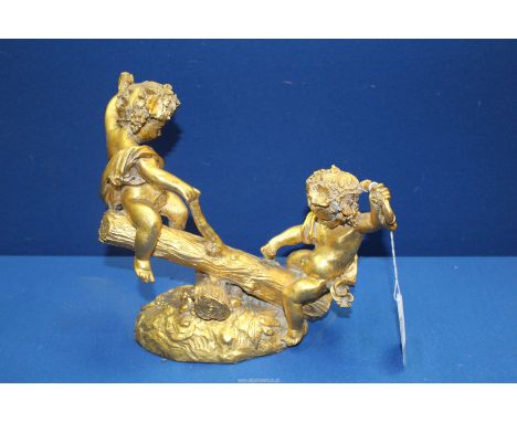 A gilt finish model of two nymph type children playing on a log see-saw, 9 1/2'' x 8 1/2''.