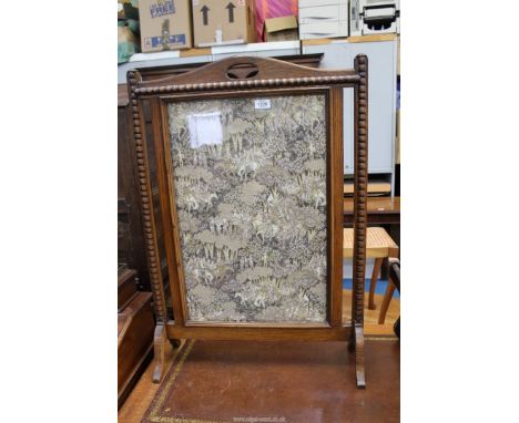An Oak framed Firescreen, the panel lined with brown/beige background fabric depicting figures on horseback making their way 