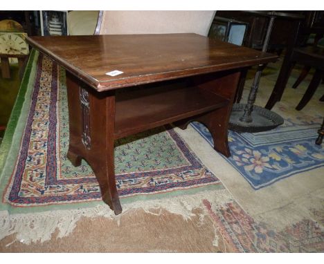 A low rectangular Mahogany arts and crafts design Table standing on slab end supports with carved depictions of stylised art 