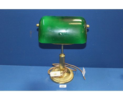 A brass bankers lamp with green glass shade, 15'' tall.