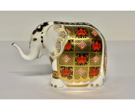 A Royal Crown Derby paperweight, Imari Elephant, trunk raised, decorated in the 1128 pattern, gold stopper, 11cm high, printe