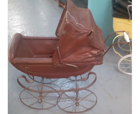 Late Victorian/Edwardian doll's pram with folding canvas canopy, ceramic handle and sprung frame on metal wheels.   (B.P. 21%