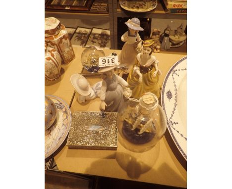 Four ceramic lady figurines, silver handled cake knife, ship in a bottle etc 