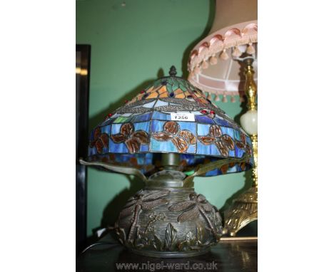 A Tiffany design table Lamp, the base depicting dragonflies in relief, the shade also depicting dragonflies in vivid glass co