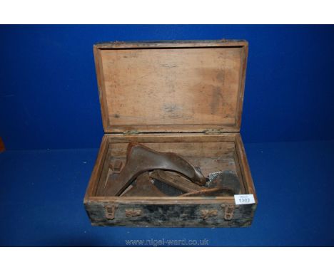 A pair of vintage cast iron Cobblers shoe lasts in a wooden box.
