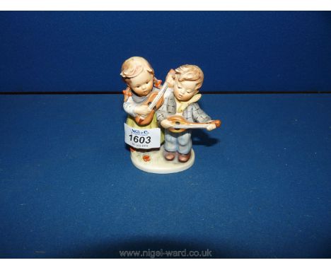 A Goebel figurine of Two children singing and playing instruments.