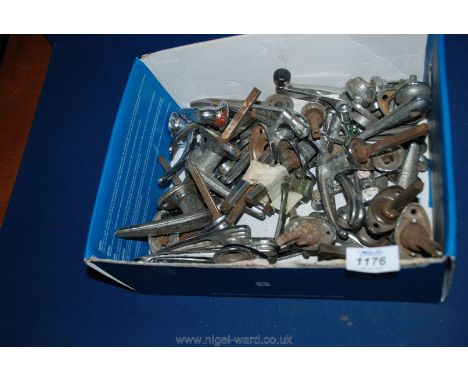 A box of vintage car parts including door handles.