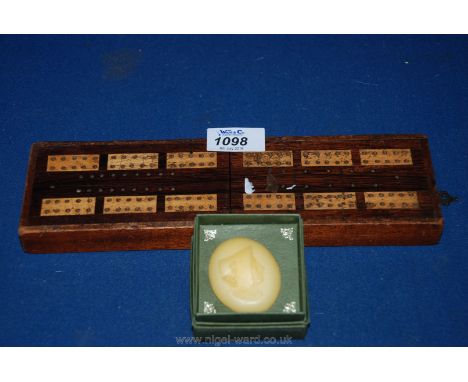 An early 20th c. Mahogany and boxwood cribbage Board plus a Madame Tussards wax Profile of a lady in a bonnet.