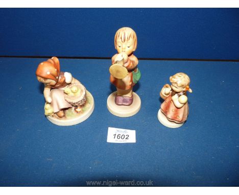Three Goebel figurines including Little girls with chicks, Angel blowing trumpet and Girl with basket.