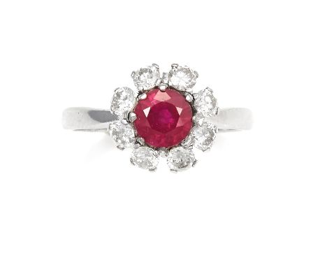 A RUBY AND DIAMOND CLUSTER RING in platinum, the round cut ruby of 1.20 carats encircled by round cut diamonds totalling 0.75