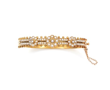 AN ANTIQUE PEARL BANGLE, 19TH CENTURY in high carat yellow gold, half jewelled with pearl cluster motifs, and accented with g