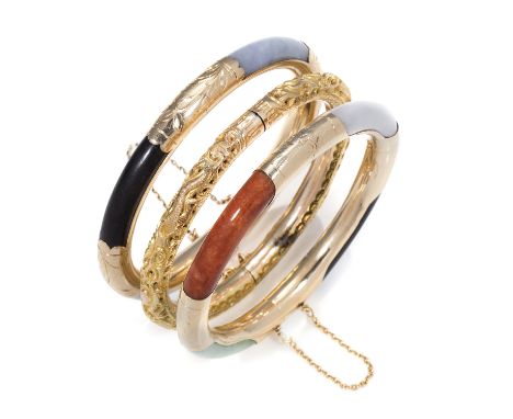 TWO JADEITE JADE AND ONYX BANGLES in yellow gold, each set with four panels of polished variously coloured jade and onyx betw