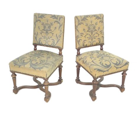 A pair of early 20th century oak side chairs, with carved frames, tapestry upholstered seats and backs, shaped X stretchers, 
