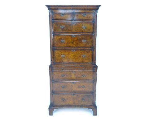 A reproduction walnut veneered tallboy, in George III style with herringbone crossbanding, with outswept cornice over two sho