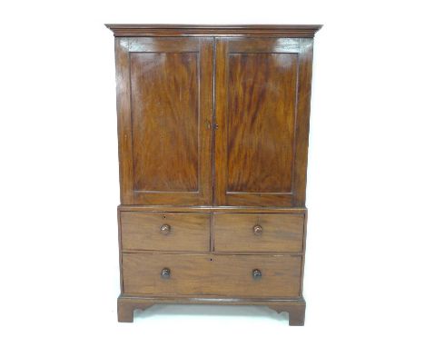 A Georgian mahogany linen press, with two doors enclosing a hanging space (press slides missing), over two short and one long