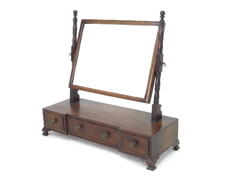 A Victorian mahogany toilet mirror, rectangular plate in a cushion moulded frame, turned supports, breakfront base with three