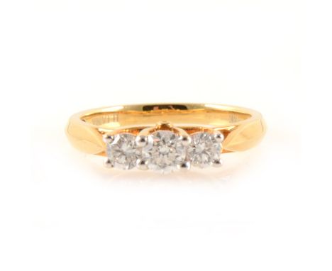 A diamond three stone ring, the brilliant cut stones graduating in size claw set in an 18 carat all yellow gold mount, total 