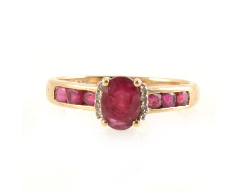 A ruby solitaire ring with ruby shoulders, the oval mixed cut ruby 7mm x 5mm, four claw set with four small diamonds set to e