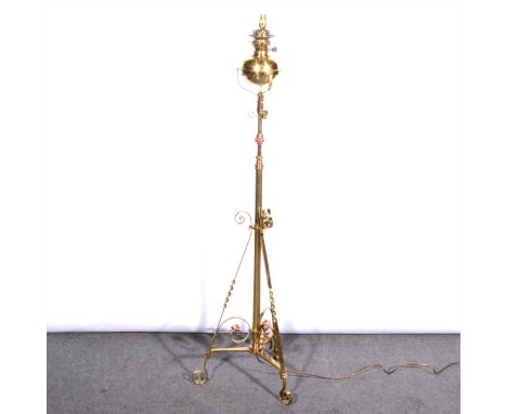 An English Art Nouveau lacquered brass and copper adjustable standard lamp, manner of Benson, scrolled tripod base, converted