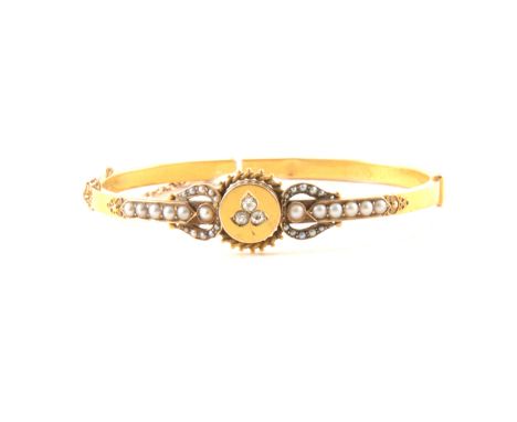A Victorian half hinged bangle set with three diamonds as a leaf motif to a circular disc to the centre with a twisted wire b