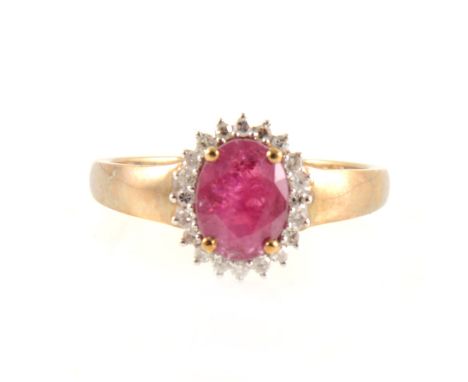 A ruby and diamond oval cluster ring, the oval mixed cut ruby 8mm x 6mm, four claw set and surrounded by twenty diamonds in a