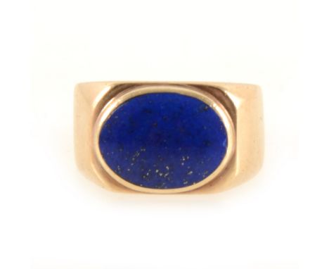 A lapis lazuli dress ring, the oval cabochon cut stone 14mm x 10mm, collet set in a 9 carat yellow gold signet mount with clo