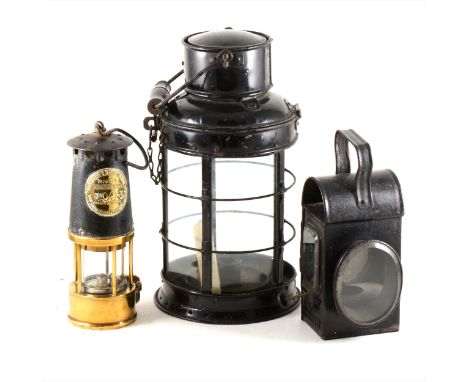 A brass and steel miners safety lamp, model SL, Protector Lamp and Lighting Co Limited, 25cm; a coach lamp, and a storm lamp.