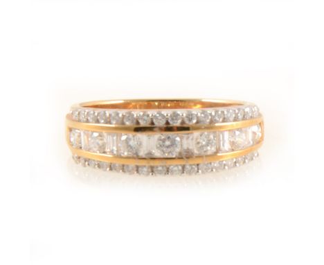 A diamond three row eternity ring, seven brilliant cut diamonds spaced by six baguette cut diamonds channel set with a border