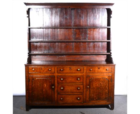 Joined oak dresser, late 18th century, with a three shelf delft rack under an ogee moulded cornice, the base with three friez