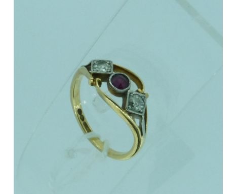 A dress Ring, set in the centre with a circular cut ruby with diamonds on either side, all millegrain set in white gold, in a