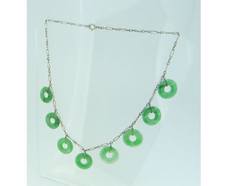 A Necklet,  formed of eight green jade open circle drops, mounted on a fine metal link chain, each jade disc ¾in (1.8cm) diam