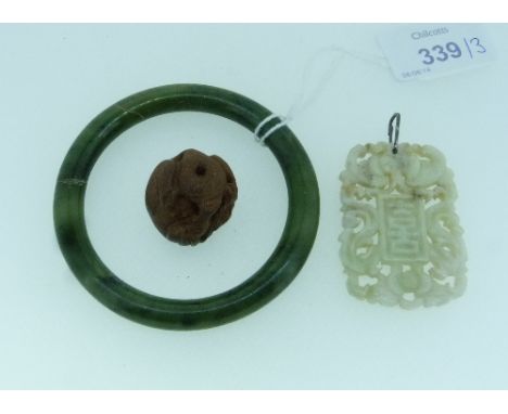 A pale celadon jade Pendant, of pierced rectangular form with suspension hole, together with a mottled green jade bangle and 