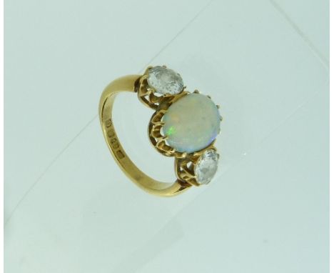 An opal and diamond Ring, the central oval opal, with a facetted diamond on each shoulder, all in 18ct yellow gold claw setti