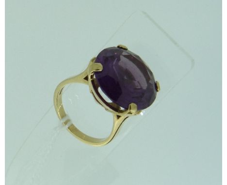 A large Dress Ring, set with a large circular facetted cut amethyst, mounted in open claw setting, the shank marked 9ct, Size