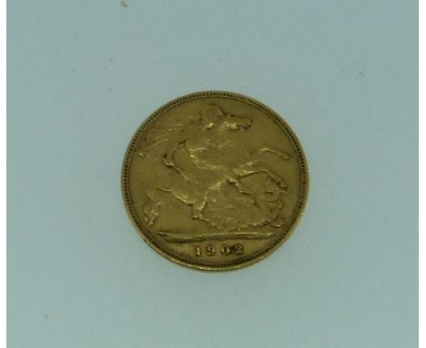 An Edward VII gold Half Sovereign, dated 1902, together with a gilt-metal sovereign case and chain (2)