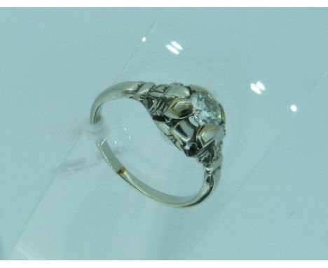 A dress Ring, set with a central facetted diamond in a petal shape and stepped mount with a small diamond point on each shoul