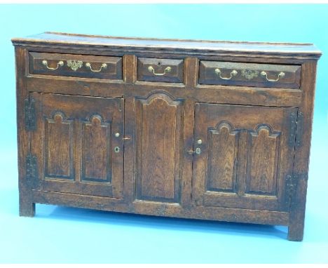 An Early 18th Century Provincial oak Dresser, with naive moulded plank top and joyned frame and panel carcass, having three f