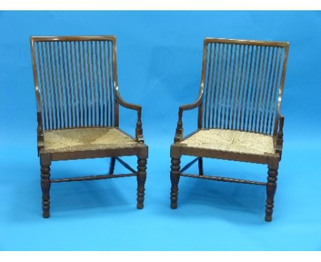 A Pair of Arts and Crafts mahogany Stick Back Chairs, with rush seats, one with minor repairs (2)