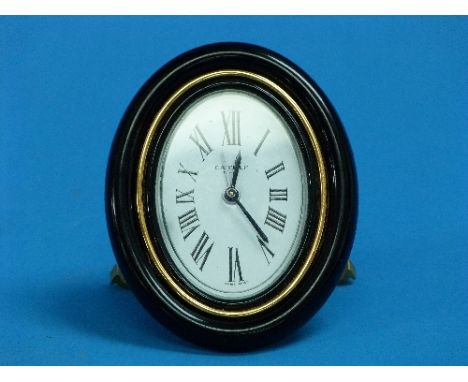 A Cartier (Paris) Pendulette Travel Alarm Clock, circa 1978, gold plated with sapphire blue winders, the oval dial with black