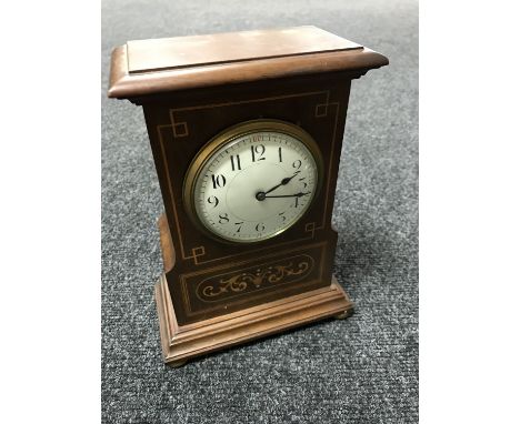 A Victorian inlaid mahogany mantel clock with enamelled dial on brass feet 