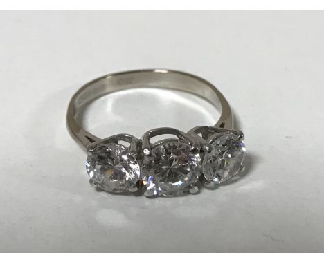 An 18ct white gold three stone dress ring, size N.