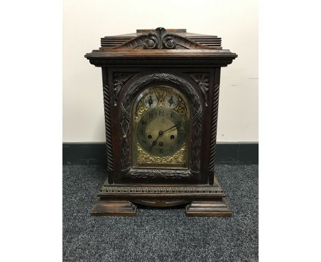 A carved oak chiming bracket clock with brass dial 