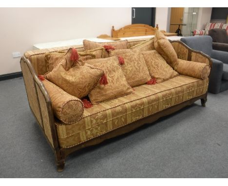 A 20th century French day bed upholstered in a classical print and a quantity of cushions in the same fabric 