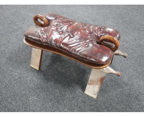 A 20th century camel stool with button leather cushion 